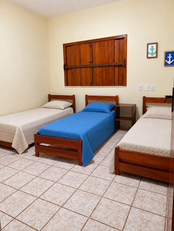 Quarto com três camas de solteiro